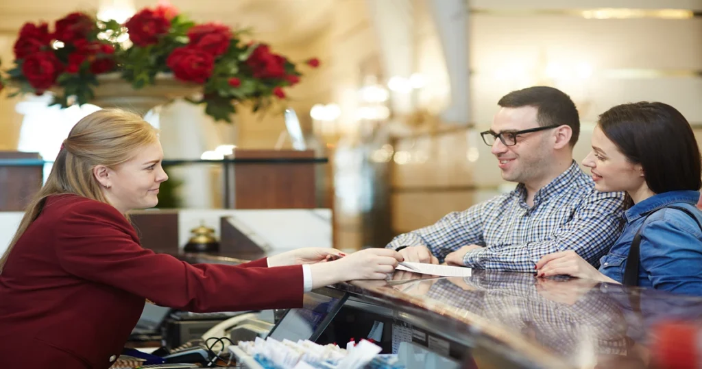 Hotel reception where guests are checking in to the hotel and receptionist is assisting them