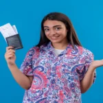 Beautiful woman standing with passport and air tickets